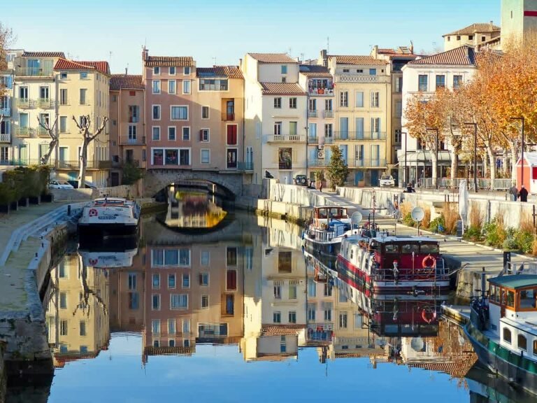 Vue du pont des marchands à Narbonne traversant le canal de la Robine avec ses maisons colorées